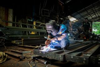 Soudeur assemblant un bâti en profilés d'acier
