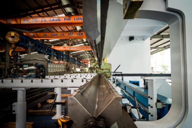 Presse-plieuse moderne en train de plier une pièce de tôle dans un atelier