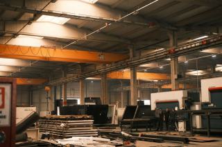 Atelier de tôlerie avec ponts roulants, machines et piles de tôles