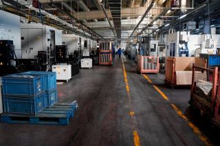 Allée d'usine avec bacs de pièces et postes de production